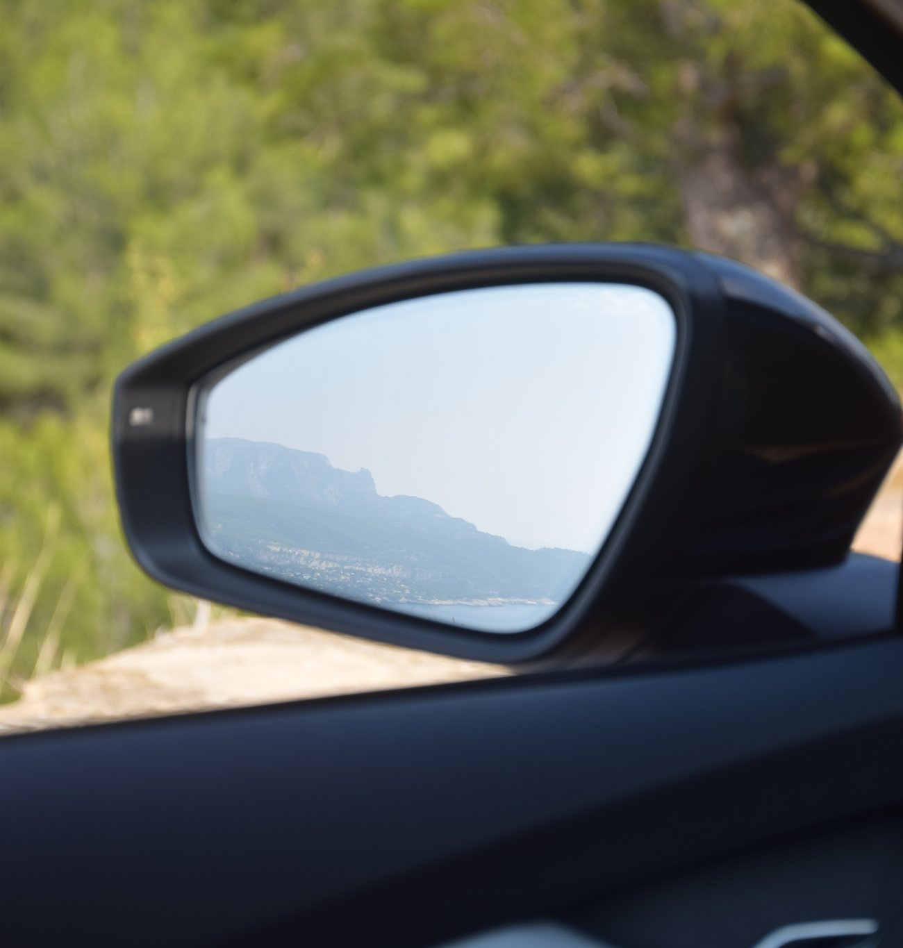 Le rétroviseur extérieur, qui ne reflète que la route et les collines
